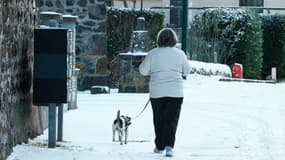 Personne marchant sur une route enneigée dans le village de Nebouzat, dans le Puy-de-Dôme, en Auvergne, le 20 novembre 2025.