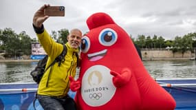 Un homme pose avec une phryge, mascotte des Jeux olympiques, le 26 juillet 2024 à Paris.