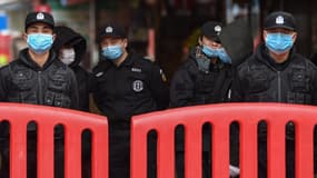 Des policiers et agents de sécurité avec des masques de protection respiratoire, à Wuhan (Chine) le 24 janvier 2020