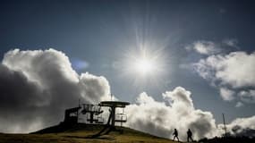 Des randonneurs près des remontées mécaniques à l'arrêt à cause du manque de neige dans la station de ski française Le Semnoz, près d'Annecy, le 27 décembre 2022. 