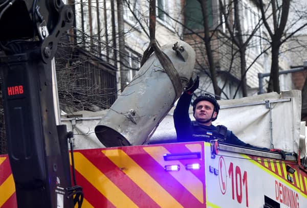 Un démineur ukrainien charge un fragment de missile dans un camion après une frappe russe près d'un immeuble résidentiel de Kiev le 21 mars 2024