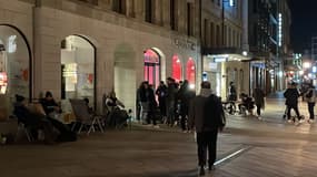 Des clients patientent devant une boutique Swatch à Genève, dans la nuit de vendredi à samedi 26 mars 2022, pour la sortie de la MoonSwatch