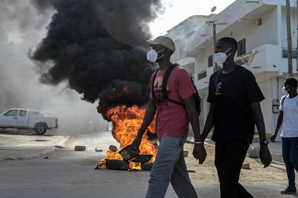 Des manifestants passent devant une barricade en feu, après l'annonce du report de la présidentielle, à Dakar, au Sénégal, le 4 février 2024
