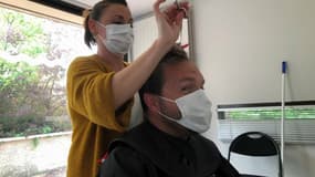 Une coiffeuse coupe les cheveux d'un soignant du CHU de Lille
