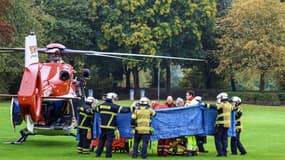 Des pompiers et des secouristes transportent Iris Stalzer, nouvelle maire de Herdecke, sur une civière avant son évacuation par hélicoptère à Herdecke, dans l'ouest de l'Allemagne, le 7 octobre 2025