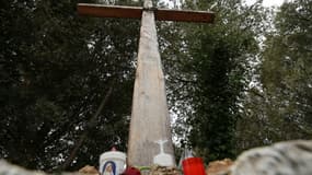 Des bougies déposées au pied d'une croix en bois à l'entrée du village de Quasquara, le 14 octobre 2025 en Corse-du-Sud