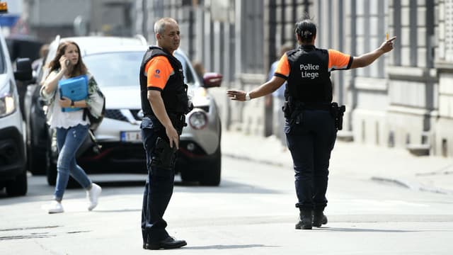 Des policiers établissent un périmètre de sécurité autour du lieu de la fusillade où deux policiers et un civil ont été tués, le 29 mai 2018 à Liège.
