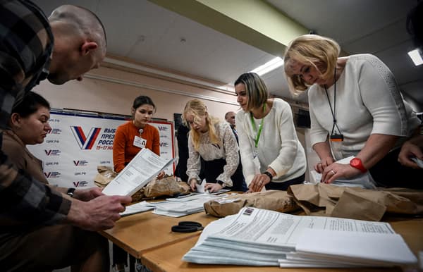 Des membres d'une commission électorale locale comptent les bulletins de vote dans un bureau de vote après le dernier jour des trois jours de l'élection présidentielle russe à Moscou, le 17 mars 2024.