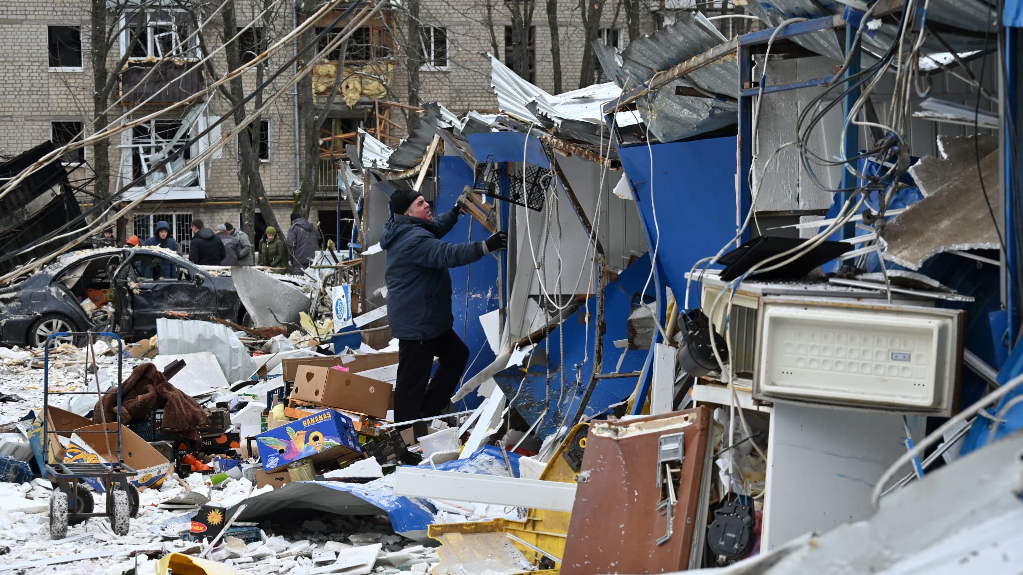 Un homme dégage les débris d'un marché détruit à la suite d'une attaque de missiles à Kharkiv, le 23 janvier 2024. 
