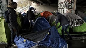Des migrants montent une tente sous un pont du canal Saint-Denis dans le 19e arrondissement parisien le 29 mars 