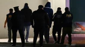 Les rugbymen français Hugo Auradou (3e d) et Oscar Jegou (3e g), escortés par la police, arrivent à Mendoza, le 11 juillet 2024 en Argentine