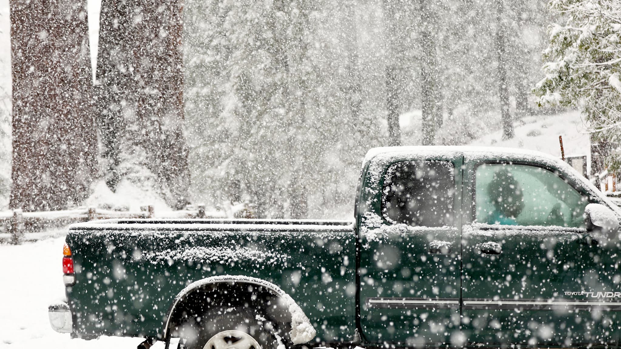 Une personne est assise dans son pick-up alors que la neige tombe pendant une tempête de rivière atmosphérique le 01 février 2024 dans le Kings Canyon National Park, Californie.