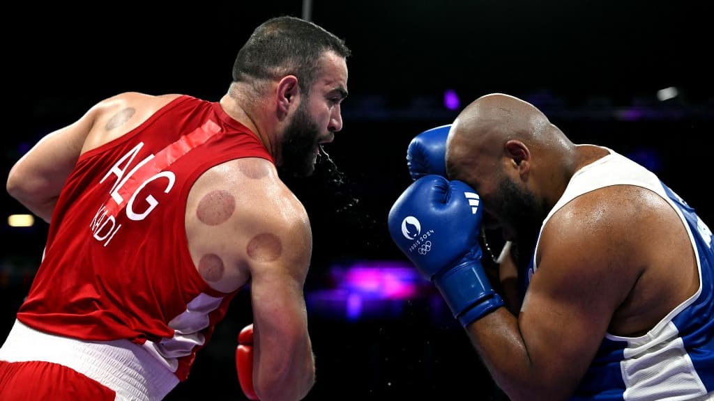 Le Français Djamili-Dini Aboudou Moindze (en bleu) combat l'Algérien Mourad Kadi lors des huitièmes de finale de la boxe masculine des +92kg pendant les Jeux Olympiques de Paris 2024 à Villepinte, le 29 juillet 2024.