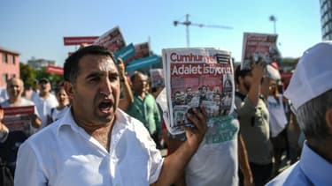Un manifestant brandit un exemplaire du quotidien Cumhuriyet avec le gros titre "Nous voulons la justice" en une, le 24 juillet à Istanbul