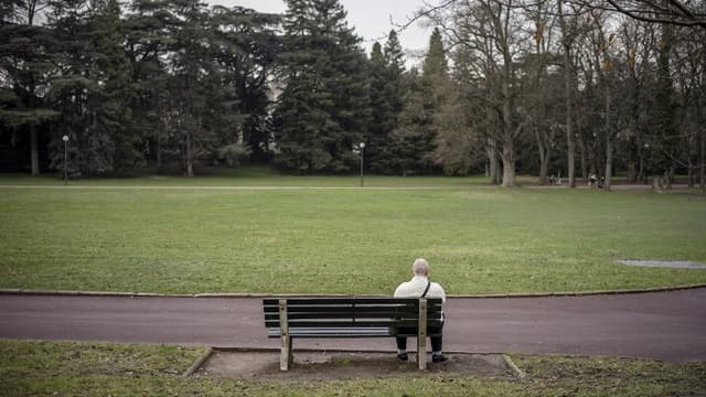Un homme assis sur un banc du Parc de la Tête d'Or à Lyon en décembre 2012