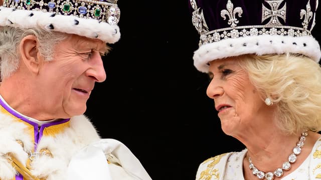 Le roi Charles III de Grande-Bretagne regarde la reine Camilla alors qu'elle se tient sur le balcon du palais de Buckingham, à Londres, après son couronnement, le 6 mai 2023. 