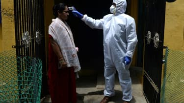 Contrôle de la température d'une habitante le 29 juin 2020 à Chennai, dans le sud de l'Inde, qui a été reconfinée le 19 juin