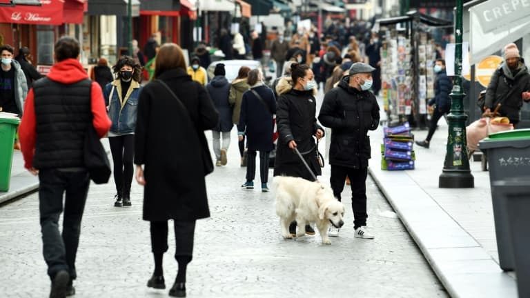 Des habitants marchent dans une rue piétonne de Paris, au premier jour d'un nouveau confinement partiel dans la capitale française à cause de la pandémie de Covid-19, le 20 mars 2021