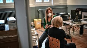 Une femme reçoit une dose de rappel du vaccin Pfizer contre le Covid-19 dans un centre de vaccination, le 27 novembre 2021 à Paris