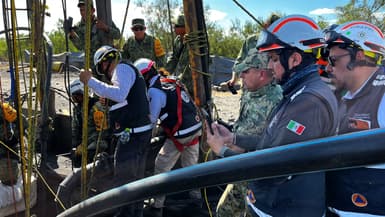 Des membres de la protection civile (SINAPROC) installant des caméras sous-marines pour pénétrer dans la mine où 10 mineurs sont piégés depuis plusieurs jours après un effondrement, dans la communauté d'Agujita au Mexique, le 8 août 2022.