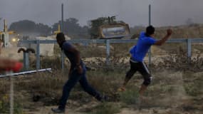 Des jeunes Palestiniens lancent des pierres à la frontière entre Gaza et Israël.