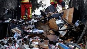 Pompiers éteignant l'incendie d'un fourgon de cigarettes attaqué par un commando, à Marseille. Un commando puissamment armé s'est emparé du contenu du fourgon pour un préjudice estimé à 700.000 euros. /Photo prise le 28 septembre 2011/REUTERS/Jean-Paul Pé