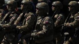 À Varsovie, en Pologne, le 15 août 2025, des soldats de l'unité militaire AGAT participent à un défilé militaire le long d'une autoroute à l'occasion de la Journée des forces armées polonaises.