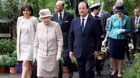 La reine achève sa visite d'Etat de trois jours par une visite du marché aux fleurs de Paris rebaptisé "marché aux fleurs Reine Elizabeth II". A sa droite la maire de Paris Anne Hidalgo et à sa gauche François Hollande..