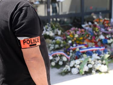 Un policier se recueille devant les fleurs déposées en hommage à Éric Masson, dimanche 9 mai 2021, devant son commissariat d'Avignon