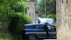 Une voiture de gendarmerie bloque une voie menant à la maison où un homme a tué cinq personnes avant d'être abattu par le GIGN, le 20 juillet 2022 à Douvres, dans l'Ain