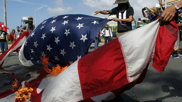 Des manifestants brûlent un drapeau américain, durant le référendum organisé à Porto Rico ce dimanche. 