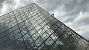 Un militant d'Extinction Rebellion sur le toit de la pyramide du Louvre à Paris, le 13 octobre 2019. 