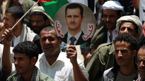 Une manifestation de Syriens brandissant le portrait de Bachar al-Assad au Yémen.