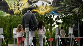 Deux fillettes accompagnées de leur père arrivent au parc zoologique de Vincennes, le 8 juin 2020 à Paris