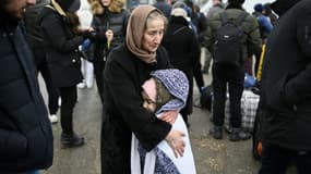 Une femme réconforte un enfant en attendant un mode de transport à un poste frontière entre la Moldavie et l'Ukraine près de la ville de  Palanca, le 1e mars 2022