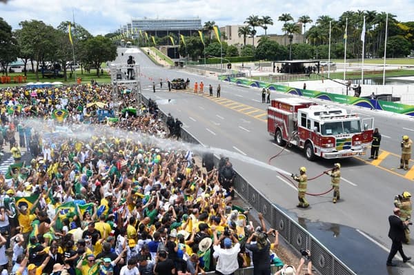Les canons à eaux arrosent la foule qui attend l'investiture de Jair Bolsonaro ce mardi à Brasilia au Brésil.