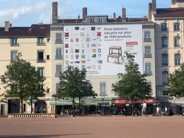 Une bâche publicitaire géante sur la place Bellecour, dénoncée par les élus écologistes lyonnais le 15 avril 2024.