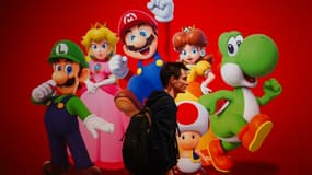 Un visiteur passe devant l'affiche du jeu vidéo "Super Mario" de Nintendo lors de la soirée de préouverture du salon "Paris Games Week" à Paris, le 22 octobre 2024