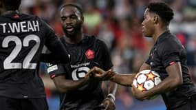 L'attaquant canadien de Lille, Jonathan David (d), est félicité par l'attaquant Jonathan Ikoné, après avoir égalisé sur pénalty face à Séville, lors de la 4e journée de la phase de groupes de la Ligue des Champions, le 2 novembre 2021 au Stade Ramon Sanchez Pizjuan
