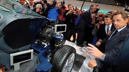 Nicolas Sarkozy et le ministre de l'Ecologie, Jean-Louis Borloo, au Salon de l'automobile à Paris. Le chef de l'Etat a pressé une nouvelle fois vendredi les constructeurs automobiles français de ne pas délocaliser leur production, leur promettant que le g