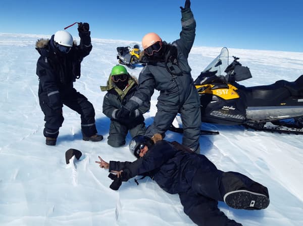 Les scientifiques devant la météorite qu'ils ont trouvée en Antarctique.