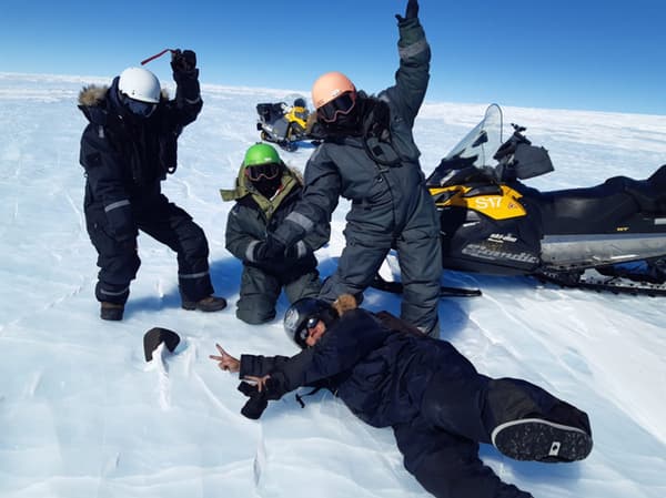 Les scientifiques devant la météorite qu'ils ont trouvée en Antarctique.