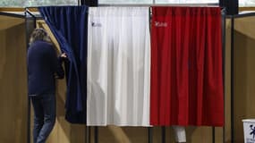 Un homme entre dans un isoloir pour voter au deuxième tour des élections législatives françaises dans un bureau de vote du Touquet (Pas-de-Calais), le 7 juillet 2024.