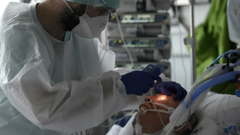 Un médecin s'occupe d'un patient atteint du coronavirus dans l'unité de soins intensifs de l'hôpital universitaire de Strasbourg, le 22 octobre 2020