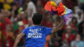 Un supporter avec un drapeau LGBT+ et un message pour les femmes iraniennes lors de Portugal-Uruguay