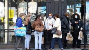 Des personnes attendent pour entrer dans un magasin de vêtements, le jour de la réouverture des commeces non essentiels, le 28 novembre 2020 à Paris
