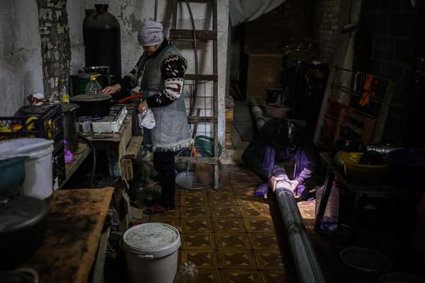 A refugee woman cooks in a basement in Bakhmut, the target of Russian strikes, Ukraine, December 1, 2022