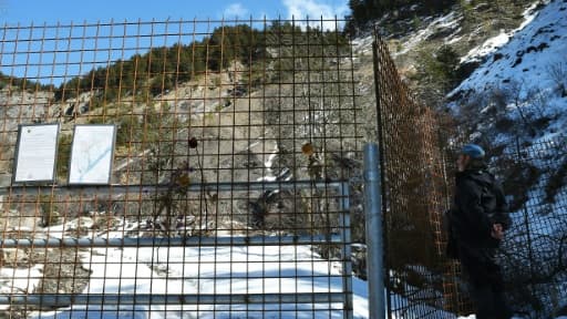 Un homme regarde à travers les barrières "sanctuarisant" le site du crash près du Vernet (Alpes-de-Haute-Provence), le 18 mars 2016 Un homme regarde à travers les barrières "sanctuarisant" le site du crash près du Vernet (Alpes-de-Haute-Provence), le 18 mars 2016