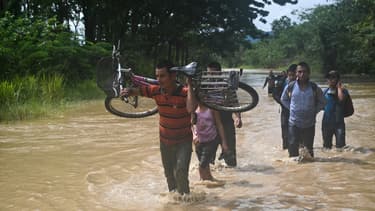 Des habitants marchent dans l'eau après le passage de l'ouragan Eta