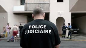 Un policier se tient devant un immeuble où cinq personnes dont un enfant sont morts dans un incendie à Pau le 10 juillet 2018